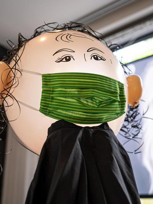 Diese aus Luftballons selbst gebastelte Puppe mit Mundschutz begruesst die Kunden ab kommenden Montag im Friseur-Salon "friseur am hag" an Dettenheim bei Karlsruhe.