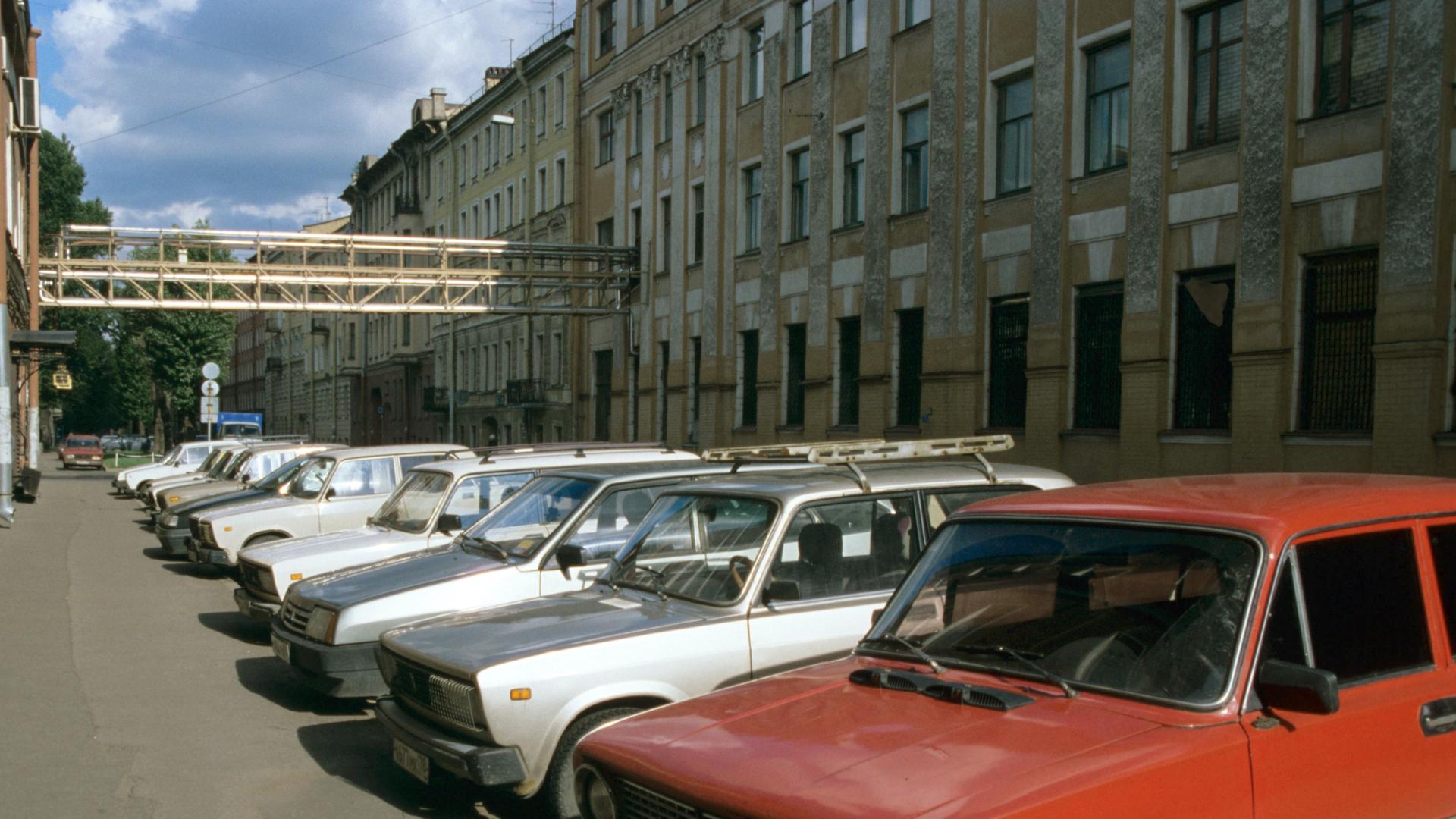 Russische Autos der Marke "Lada" parken vor einer großen Brotfabrik in St. Petersburg.