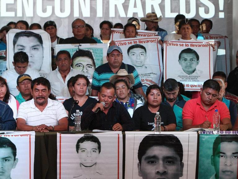 Die Eltern und Studienkollegen der 43 vermissten Studenten aus Mexiko halten Fotos von ihnen hoch.