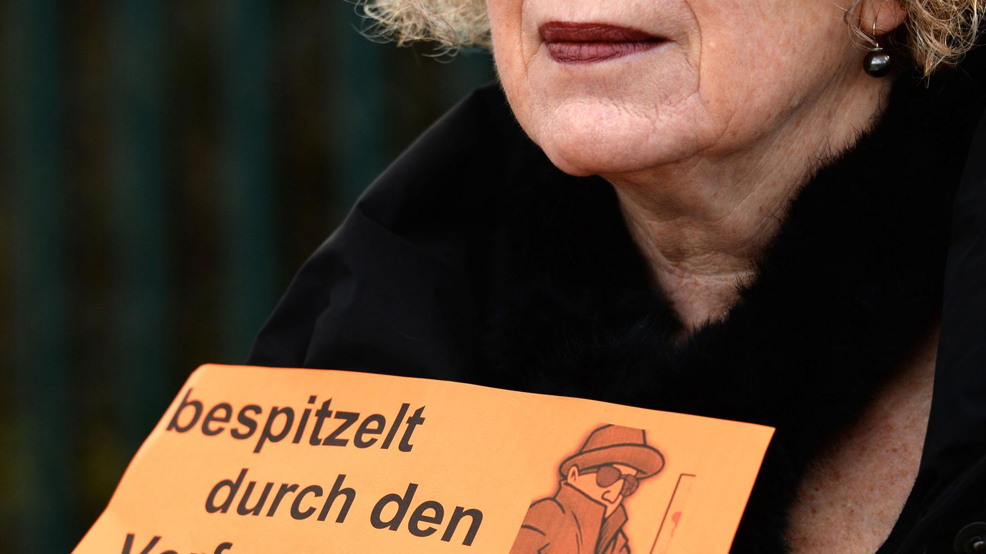 Eine Frau trägt ein Schild mit der Aufschrift "bespitzelt durch den Verfassungsschutz" bei einer Demosntration vor dem Gebäude des Landesamt für Verfassungsschutz in Hannover (Niedersachsen). Eine Frau trägt ein Schild mit der Aufschrift "bespitzelt durch den Verfassungsschutz" bei einer Demosntration vor dem Gebäude des Landesamt für Verfassungsschutz in Hannover (Niedersachsen).