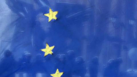 Ukrainische Polizisten stehen im Januar 2014 vor einer europäischen Flagge.
