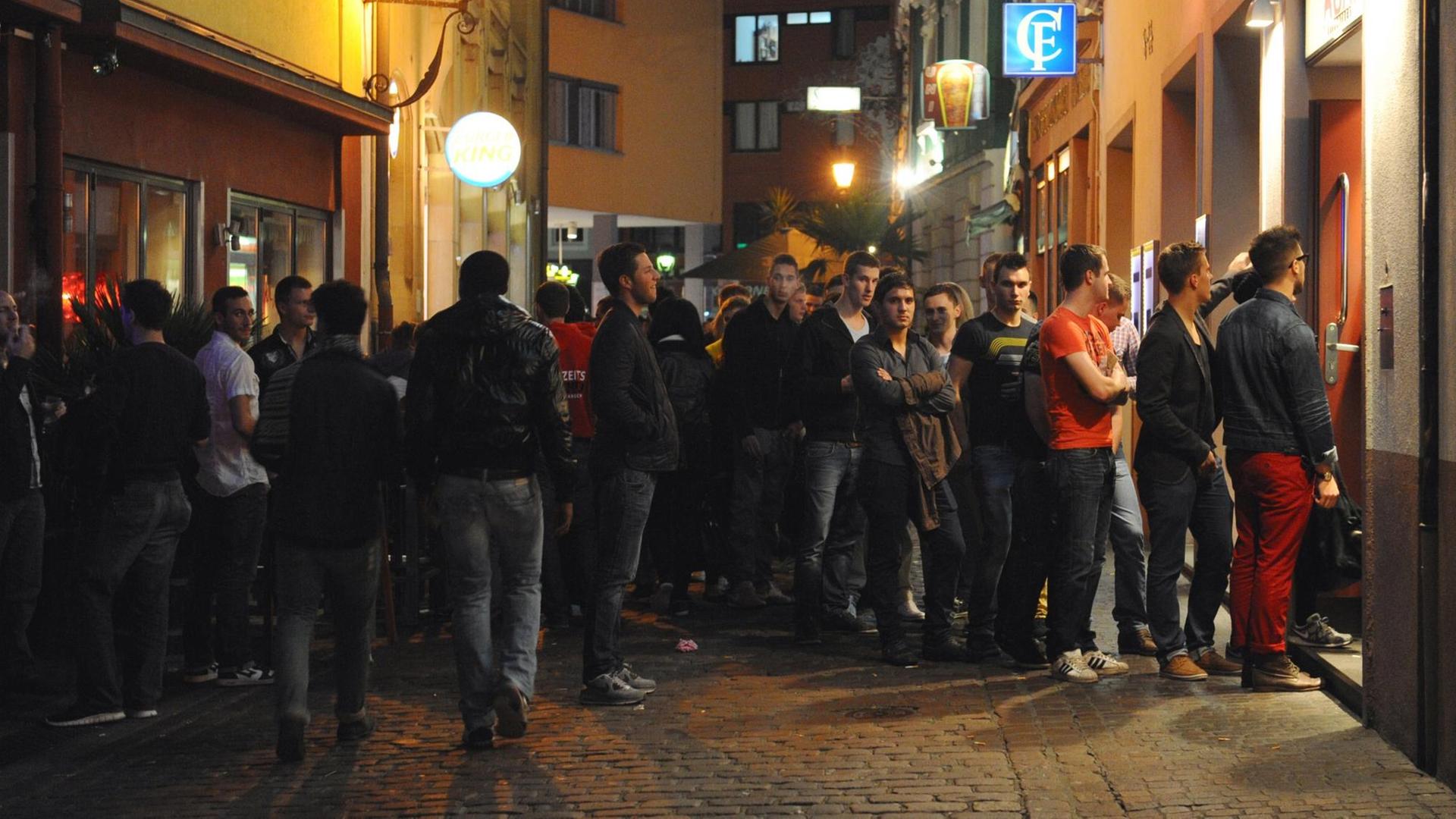 Junge Menschen stehen Schlange vor einer Freiburger Discothek.