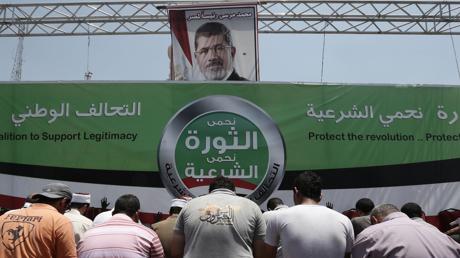 Das Bild zeigt ein Plakat, auf dem Ex-Präsident Mursi abgebildet ist