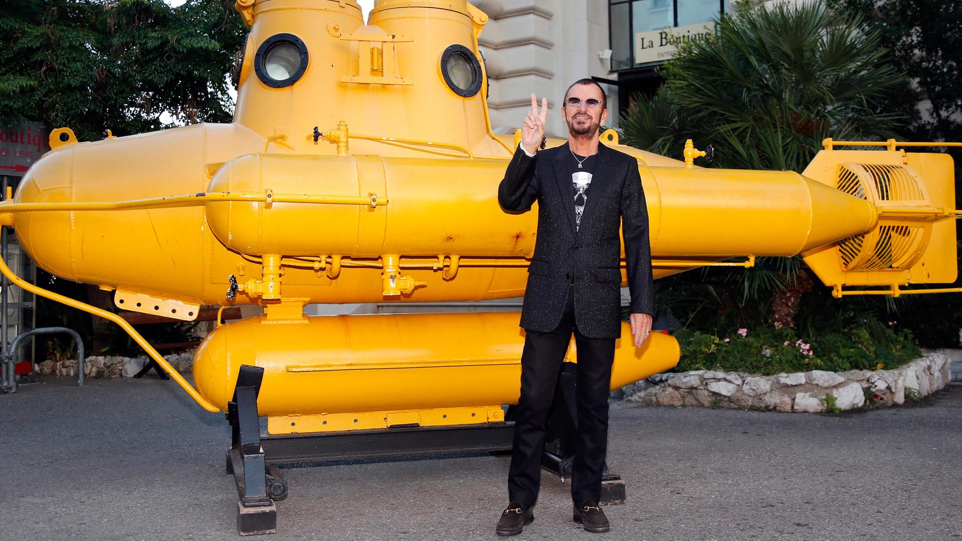 Beatle mit Yellow Submarine: Ringo Starr posiert vor einem gelben U-Boot.