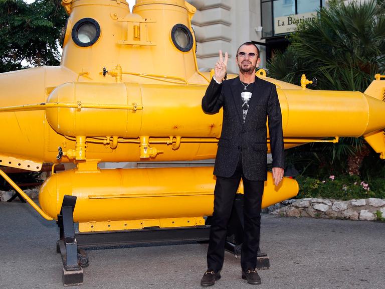 Beatle mit Yellow Submarine: Ringo Starr posiert vor einem gelben U-Boot.