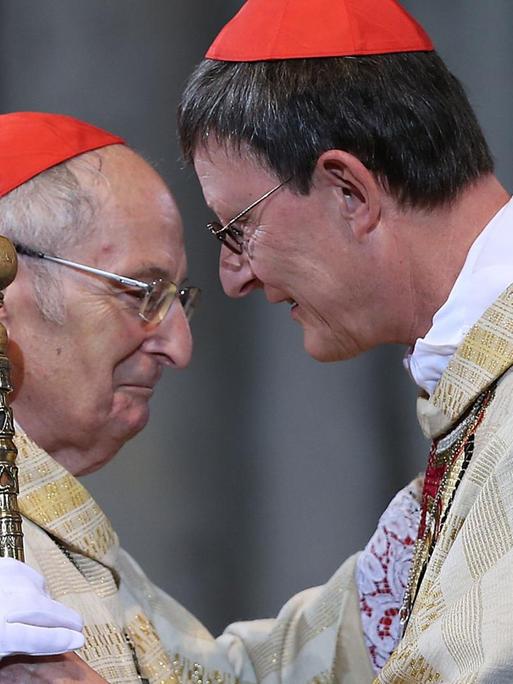 Der Kölner Erzbischof Rainer Maria Woelki (r) nimmt am 20.09.2014 in Köln von seinem Vorgänger Kardinal Joachim Meisner (l) den Petrusstab entgegen