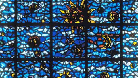 Rundes Fenster mit Glasmalerei - Die Erschaffung der Sterne - in der Stiftskirche Saint-Martin in Champeaux, Frankreich.