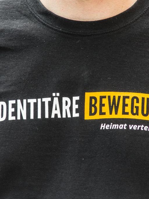 Mitglied der "Identitären Bewegung" trägt ein T-Shirt mit dem Namen der Gruppe bei einer Demonstration in München