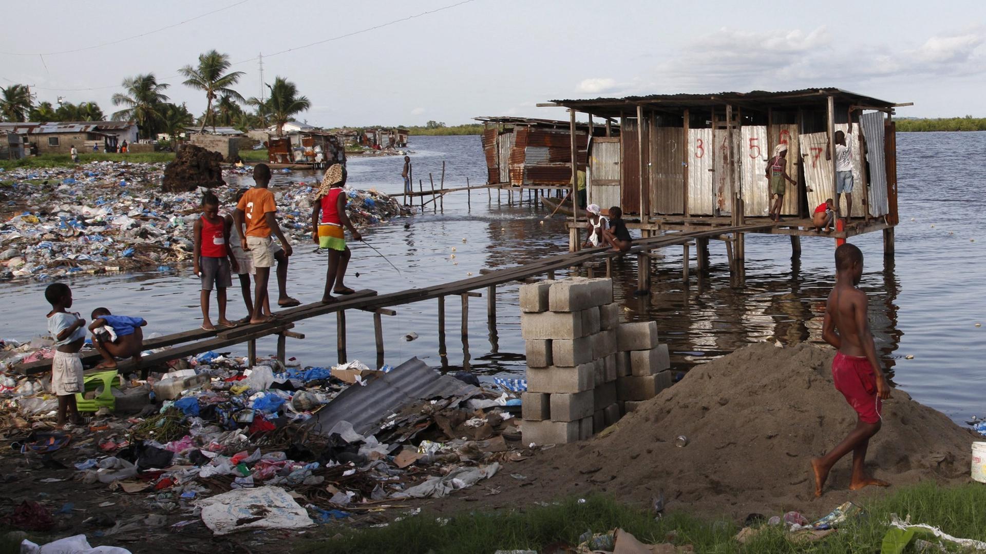 Kinder gehen an einem Fluss auf die Toilette in dem Land Liberia in Afrika.