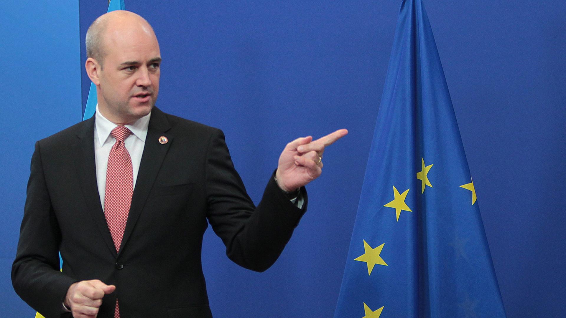 Schwedens Ministerpräsident Fredrik Reinfeldt, im Hintergrund eine Euro-Fahne