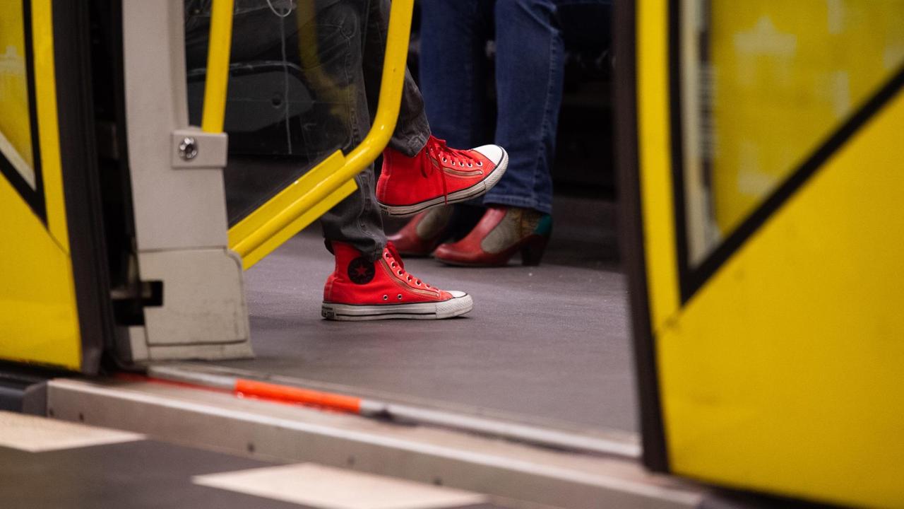  Eine Frau mit roten Schuhen sitzt in einer U-Bahn.