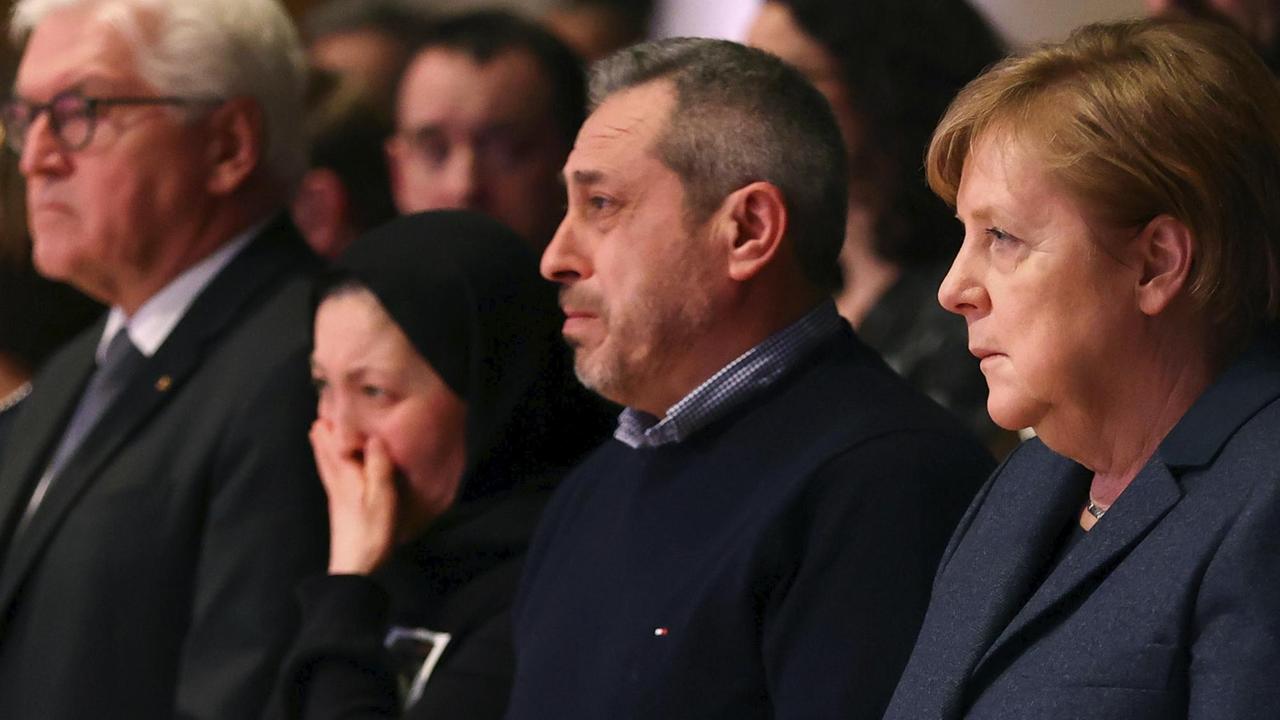 Kanzlerin Merkel sitzt bei der Trauerfeier für die Hanau-Opfer neben den Angehörigen.