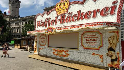 Ein Waffel-Verkaufsstand auf dem Leipziger Stadtfest, der mit Frauen in Bikinis für sein Produkt wirbt.