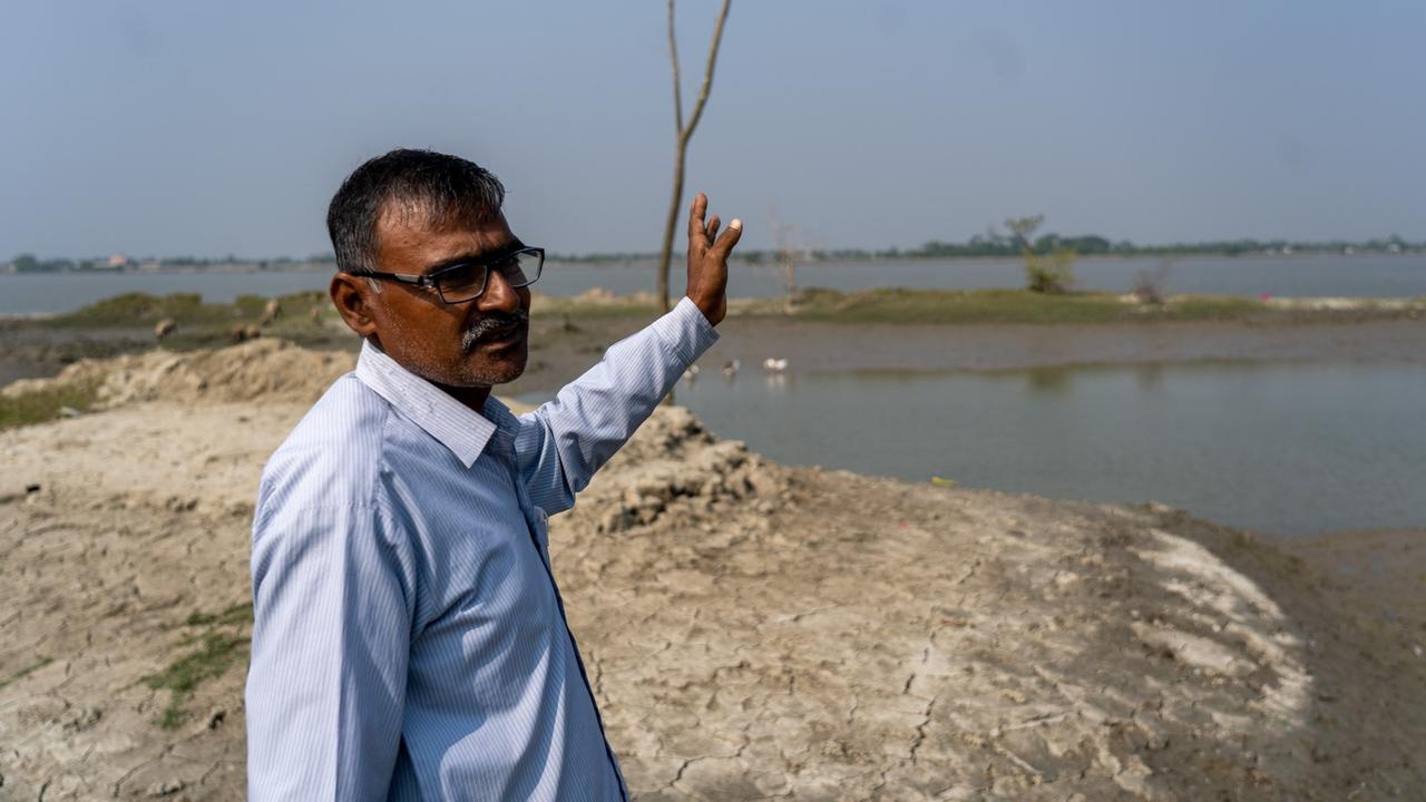Satyendra Nath deutet auf die Wasserfläche in den Hintergrund - dort standen seine drei früheren Häuser