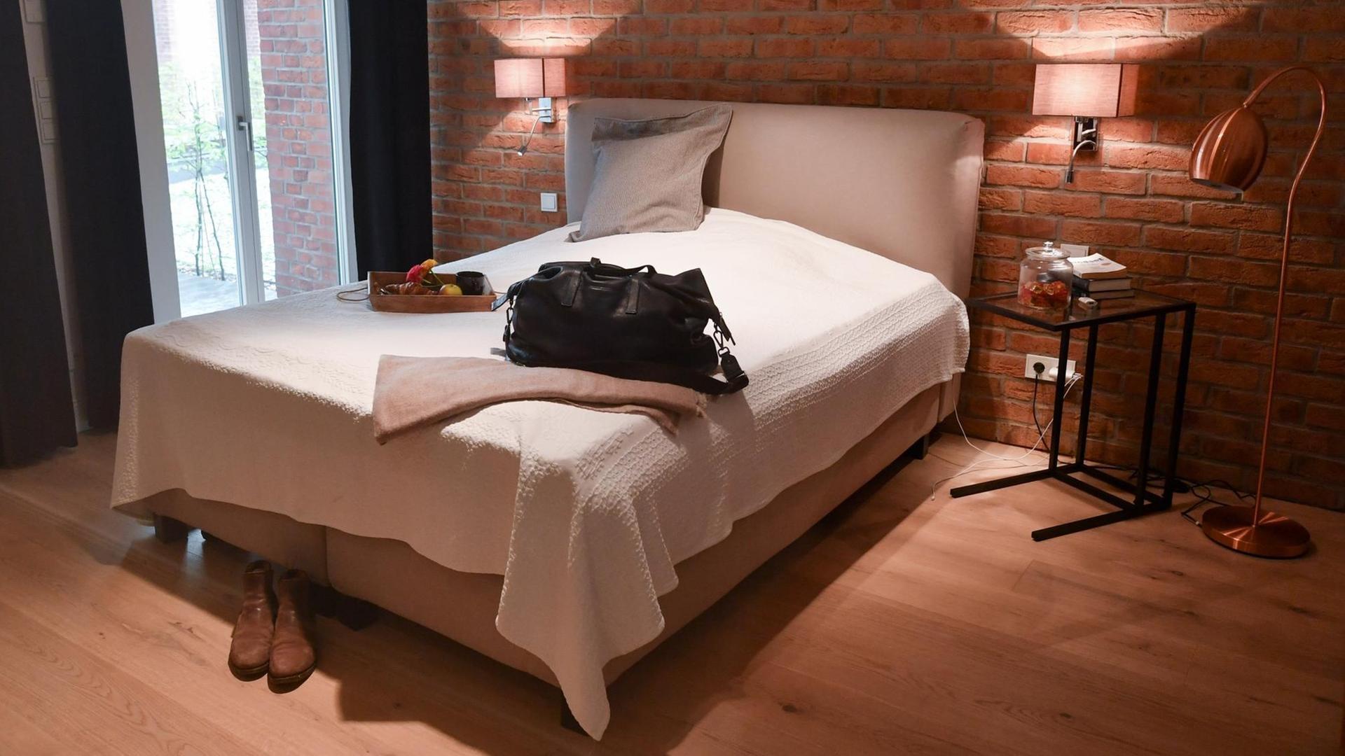 Eine Reisetasche ist in der Wohnung eines Airbnb-Gastgebers auf dem Bett im Schlafzimmer abgestellt 