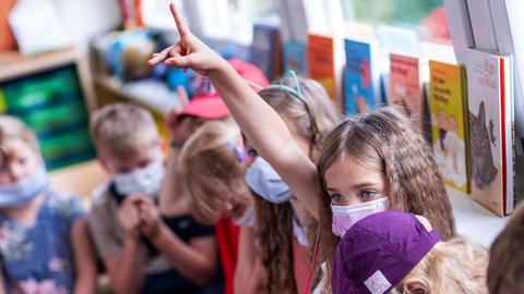 Schulanfängerin Ida meldet sich mit Mund-Nasen-Schutzmaske in der ersten Unterrichtsstunde der Klasse 1b in der Grundschule "Werner Lindemann".