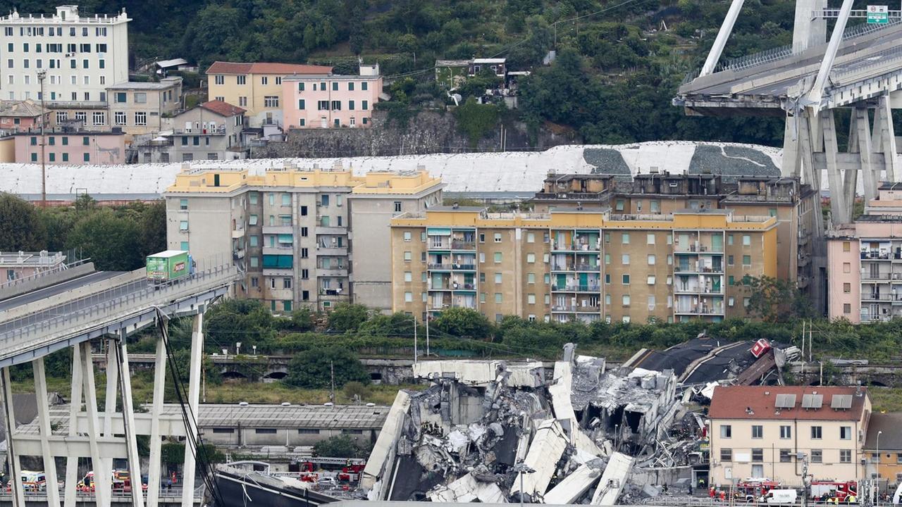 Ein Teil der Autobahnbrücke Ponte Morandi ist eingestürzt. Ein Laster (l) steht kurz vor der Lücke in der Brücke.