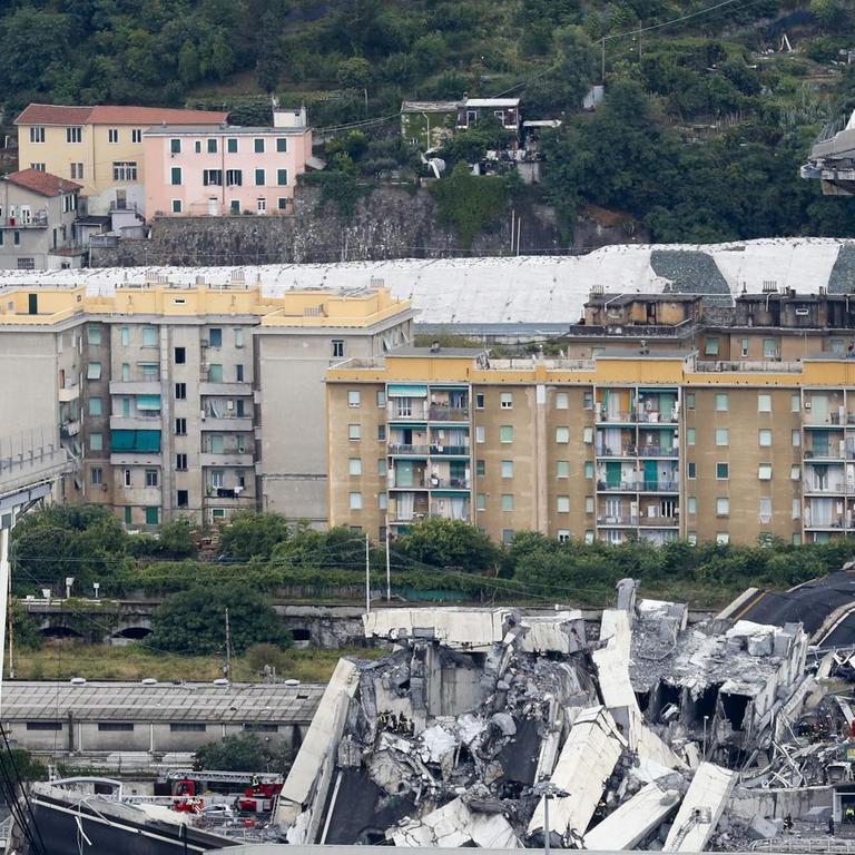 Ein Teil der Autobahnbrücke Ponte Morandi ist eingestürzt. Ein Laster (l) steht kurz vor der Lücke in der Brücke.