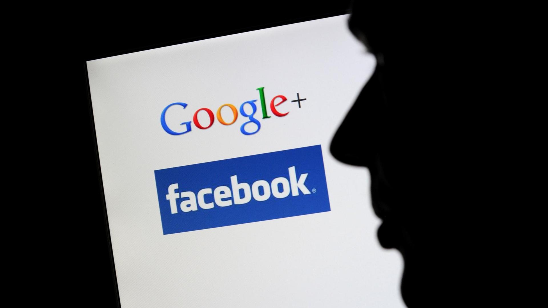 Die Silhouette eines Mannes zeichnet sich vor einem Computerbildschirm mit den Logos von Google+ und Facebook ab.
