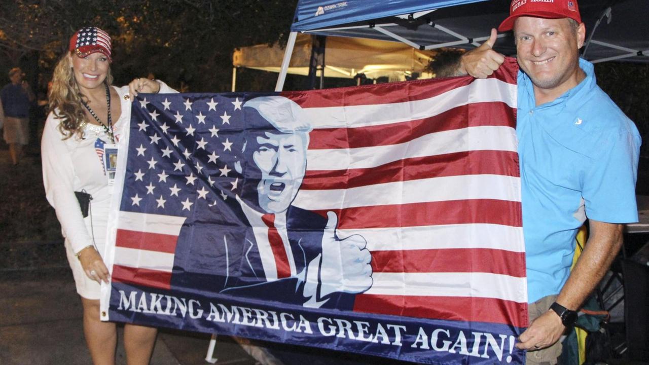 Unterstützer von US-Präsident Donald Trump halten eine amerikanische Flagge mit dem Porträt Trumps