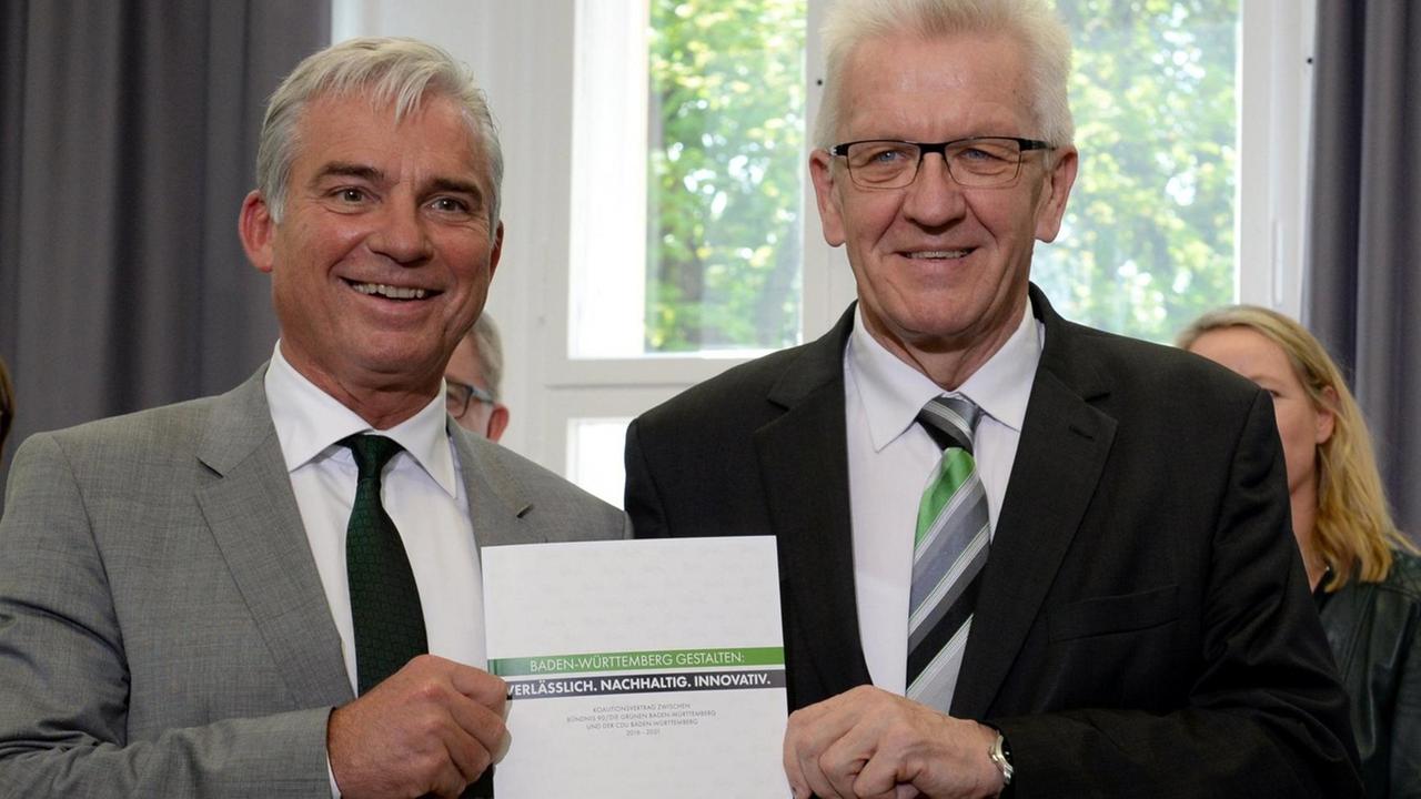 Der Ministerpräsident von Baden-Württemberg, Winfried Kretschmann (Bündnis 90/Die Grünen, r.), und Thomas Strobl, der Landesvorsitzende der CDU Baden-Württemberg, stellen am 2. Mai 2016 den grün-schwarzen Koaltionsvertrag vor.