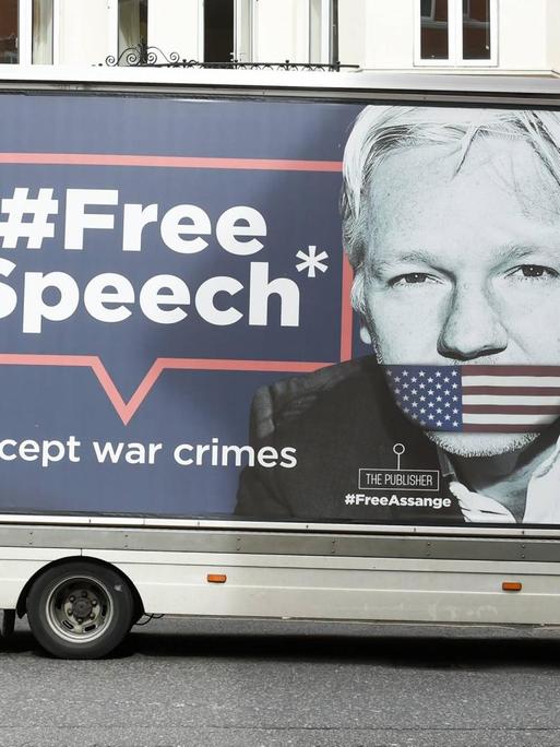 Ein Transporter mit einem Aufdruck der Gesichter von Julian Assange und Chelsea Manning steht vor der Botschaft Ecuadors in London