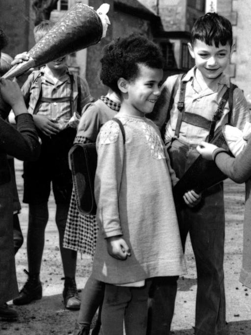 Undatierte Aufnahme: Auf dem Schulhof unterhalten sich zwei Besatzungskinder mit ihren Schulkameraden