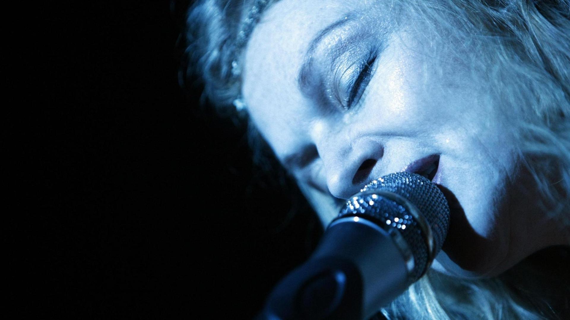 Das Foto zeigt die Popmusikerin Inga Humpe von 2raumwohnung beim Singen.