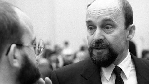 Schwarzweißaufnahme von Rainer Eppelmann in einer Gesprächssituation.