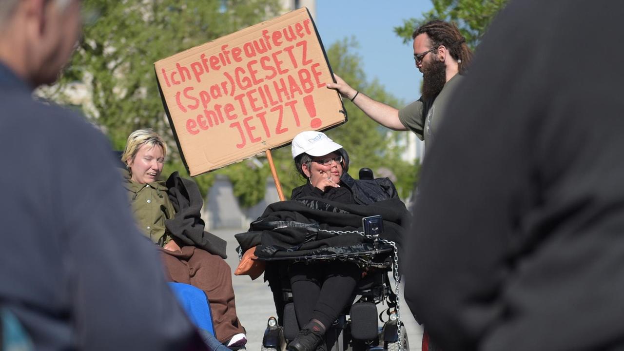 Behinderte Aktivisten demonstrieren am Spreeufer gegen das Teilhabegesetz.