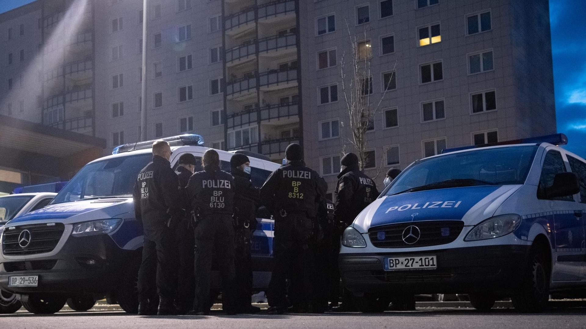 Einsatzkräfte der Bundespolizei stehen in Berlin-Lichtenberg auf einem Parkplatz und bereiten sich auf eine Razzia vor.
