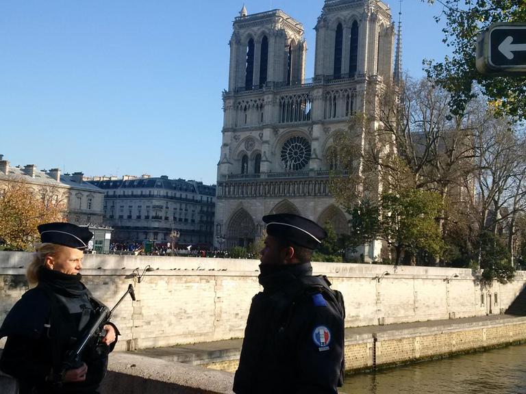 Zwei Polizisten stehen vor Notre-Dame in Paris.