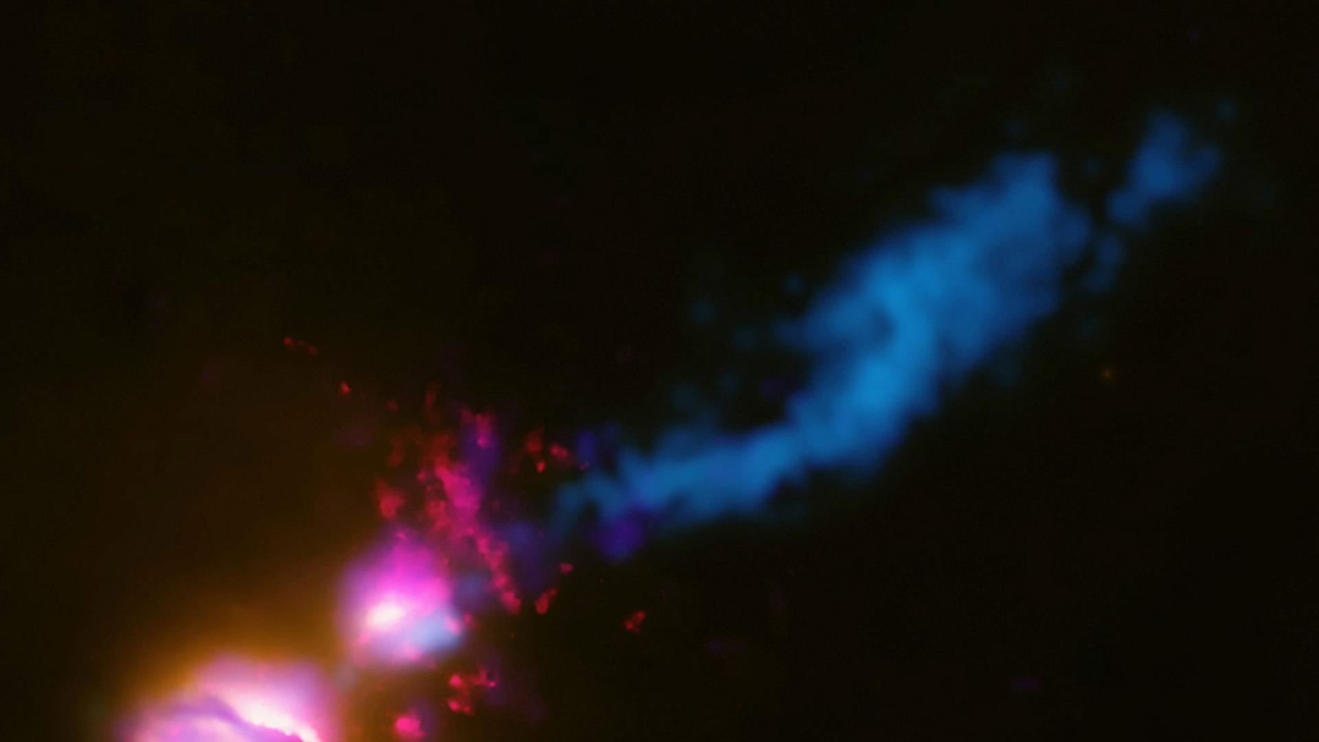 Das Bild der NASA zeigt, wie der Jet (blauer Strahl) von der Hauptgalaxie (linker unterer Fleck) ihre begleitende Galaxie (oberer Fleck) am Rande trifft. Daraufhin wird der Jet gestört und fächert sich zum rechten oberen Bildrand hin auf. Astronomen haben nach eigenen Angaben damit erstmals beobachtet, wie der Materiestrahl eines Schwarzen Loches eine benachbarte Galaxie trifft und dabei abgelenkt wird.