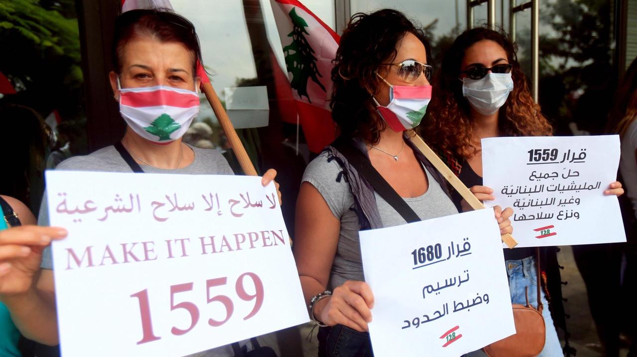 Junge Frauen protestieren gegen die Hisbollah im Juli 2020 in Beirut  im Libanon mit Plakaten in den Händen. 