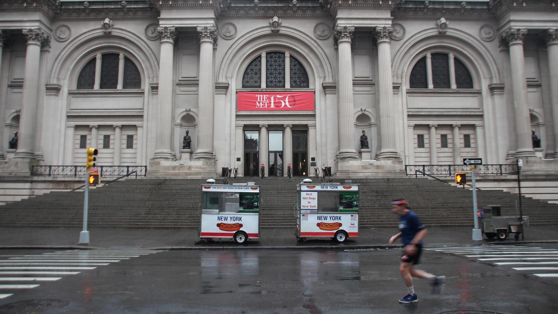 Ein Jogger läuft vor dem Eingang zum Metropolitan Museum auf der leeren Straße von New York (USA).