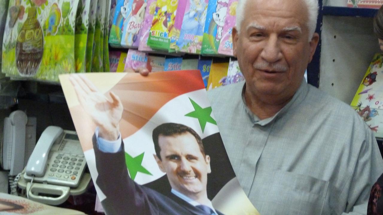 Ein Mann in Damaskus verkauft Flaggen mit Assad-Portrait.