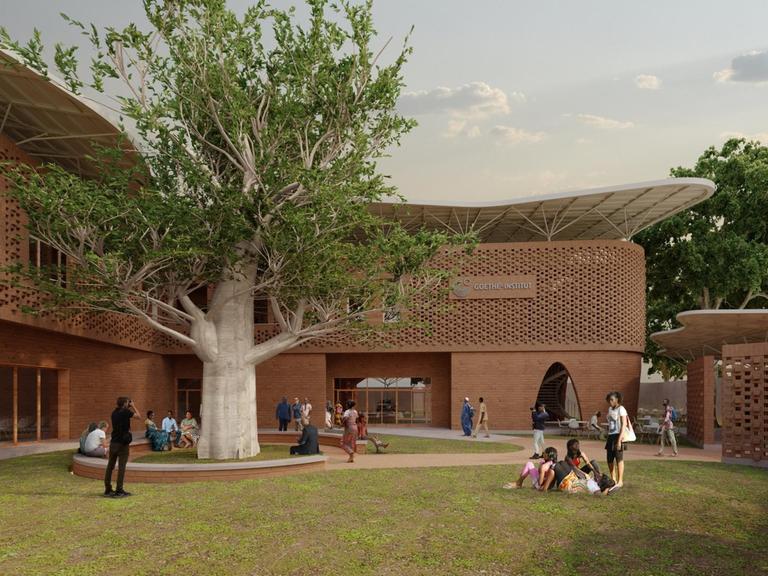 Außenansicht des Goethe-Instituts Senegal mit Besuchern auf der Wiese vor dem Gebäude.