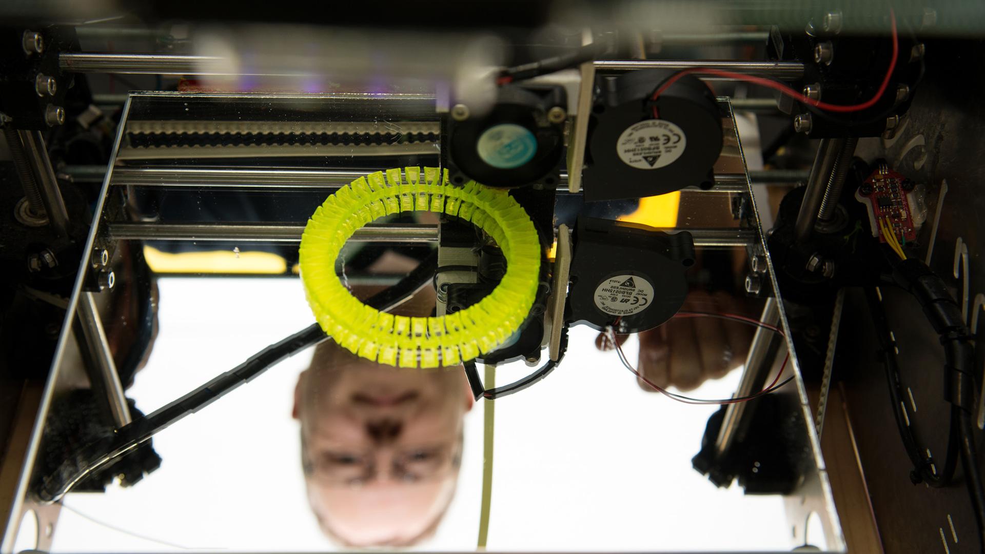 Christian Caroli von FabLab Karlsruhe steht auf der Entwicklermesse "Developer Week" in Nürnberg hinter einem 3D-Drucker, den er selbst gebaut hat.