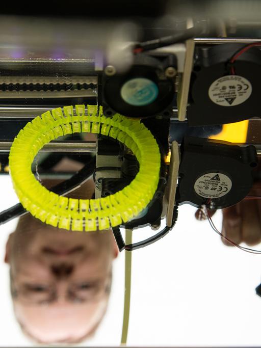 Christian Caroli von FabLab Karlsruhe steht auf der Entwicklermesse "Developer Week" in Nürnberg hinter einem 3D-Drucker, den er selbst gebaut hat.