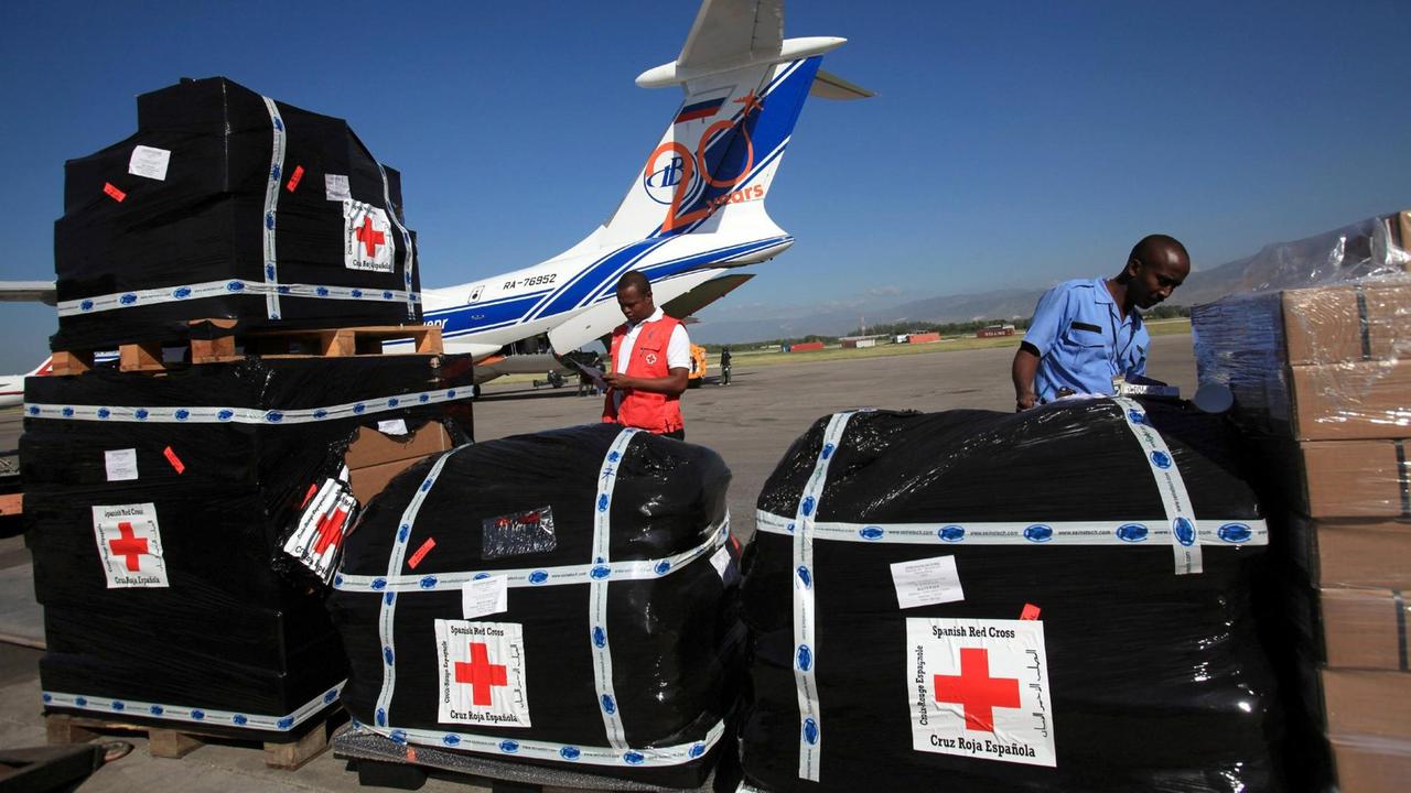 Zwei Männer mit Material einer spanischen NGO auf einem Flughafen bei Port au Prince, Haiti. 