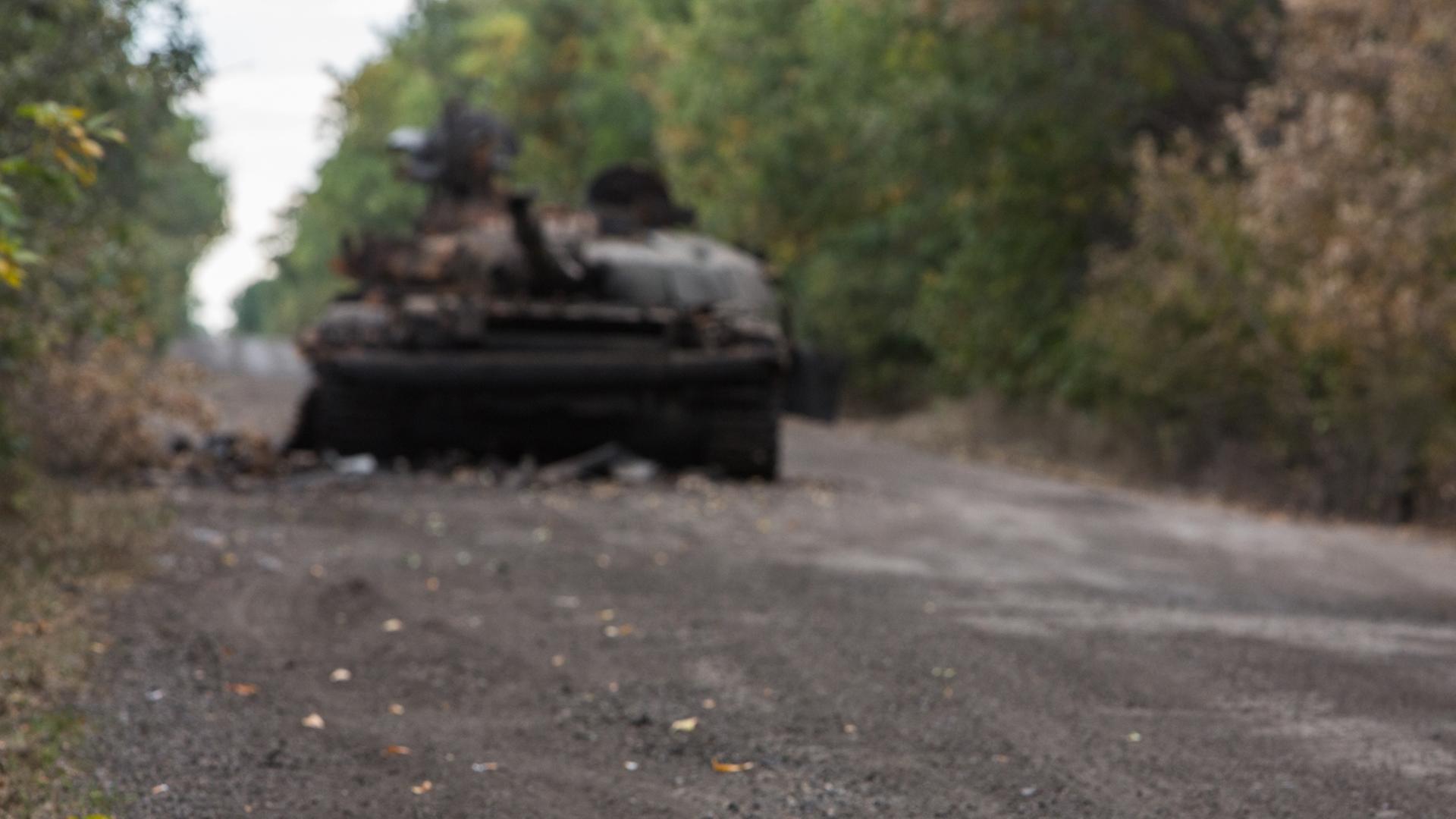 Mörsergranate und ausgebrannter ukrainischer Panzer in der Nähe von Lugansk