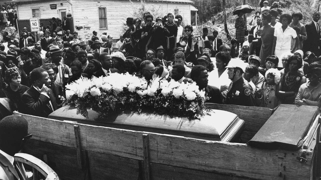 In einem schlichten Holzwagen wird am 9.4.1968 der blumengeschmückte Sarg von Martin Luther King durch seine Heimatstadt Atlanta im US-Bundesstaat Georgia gefahren. Der US-amerikanische schwarze Bürgerrechtler und Baptistenpfarrer Martin Luther King war am 4.4.1968 in Memphis im US-Bundesstaat Tennessee erschossen worden.