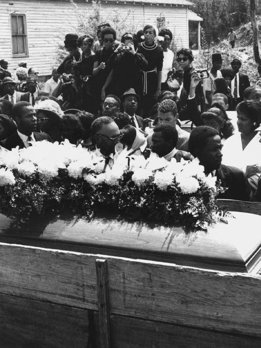 In einem schlichten Holzwagen wird am 9.4.1968 der blumengeschmückte Sarg von Martin Luther King durch seine Heimatstadt Atlanta im US-Bundesstaat Georgia gefahren. Der US-amerikanische schwarze Bürgerrechtler und Baptistenpfarrer Martin Luther King war am 4.4.1968 in Memphis im US-Bundesstaat Tennessee erschossen worden.