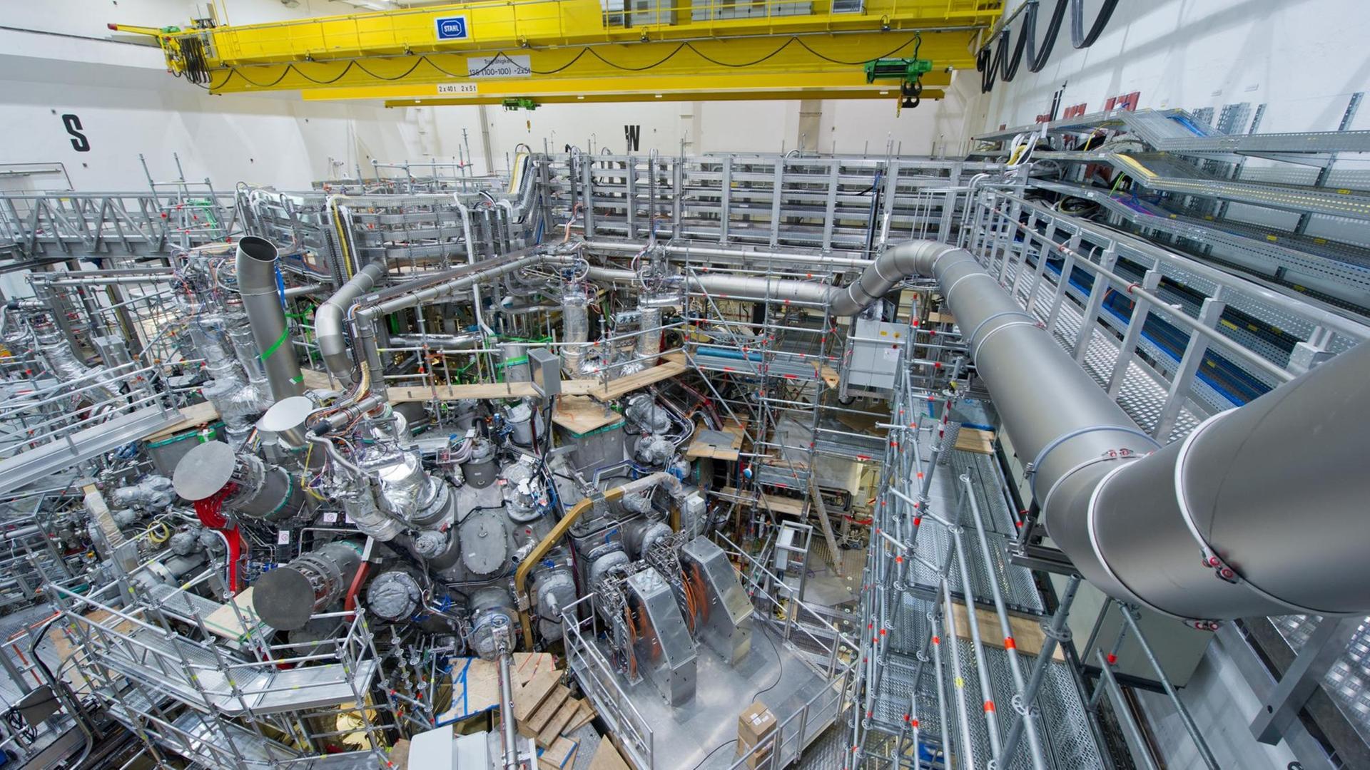 Monteure arbeiten am Max-Planck-Institut für Plasmaphysik in Greifswald (Mecklenburg-Vorpommern) an dem 725 Tonnen schweren, ringförmigen Plasmagefäß für das Kernfusionsexperiment "Wendelstein 7-X".