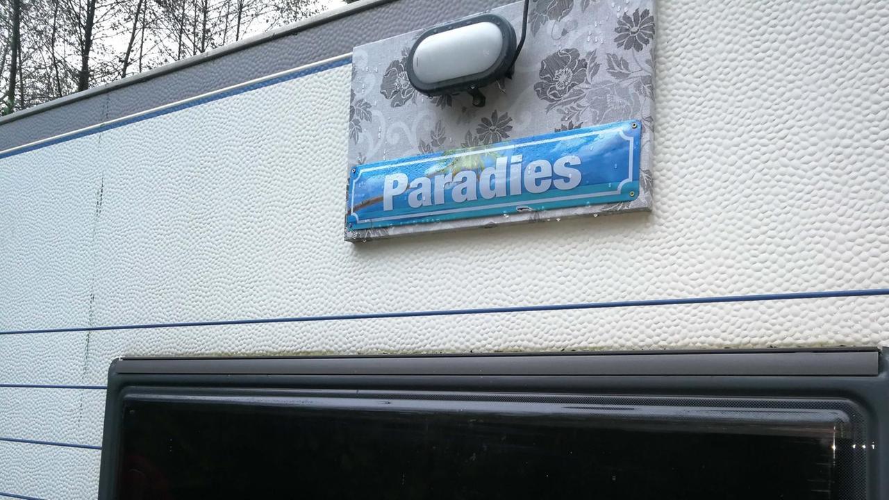 Ein Wohnwagen mit einem Schild, auf dem "Paradies" steht.