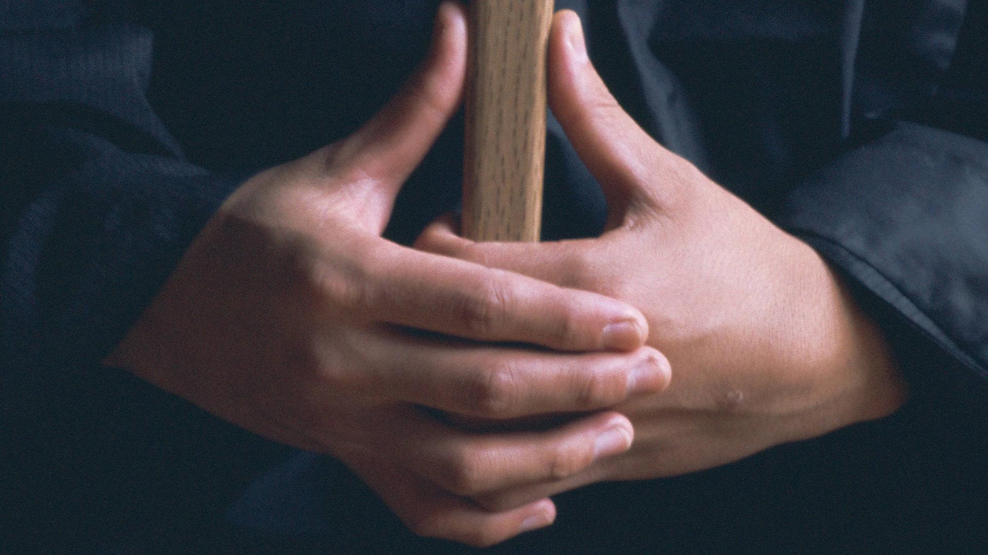 Die Hände eines Mönchs in der Zen-Position "Kyoskku"