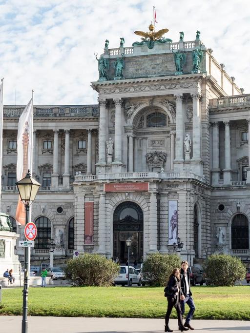 Ein prächtiger klassizistischer Bau, die Wiener Hofburg in Österreich. Ein sommerlicher Tag mit einem Schäfchenwolken und einigen Passanten.