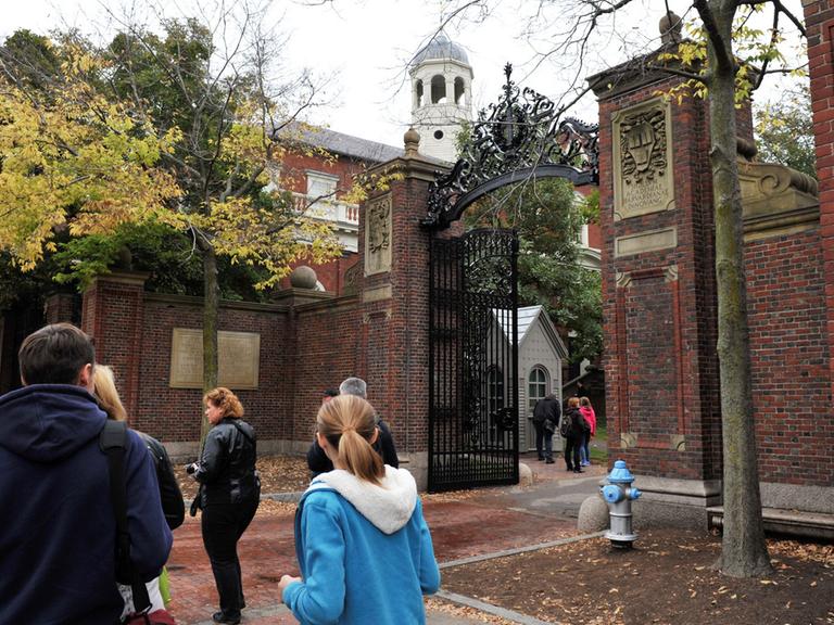 Studenten vor einem Eingang zum Campus der Harvard Universität in Cambridge im Großraum Boston