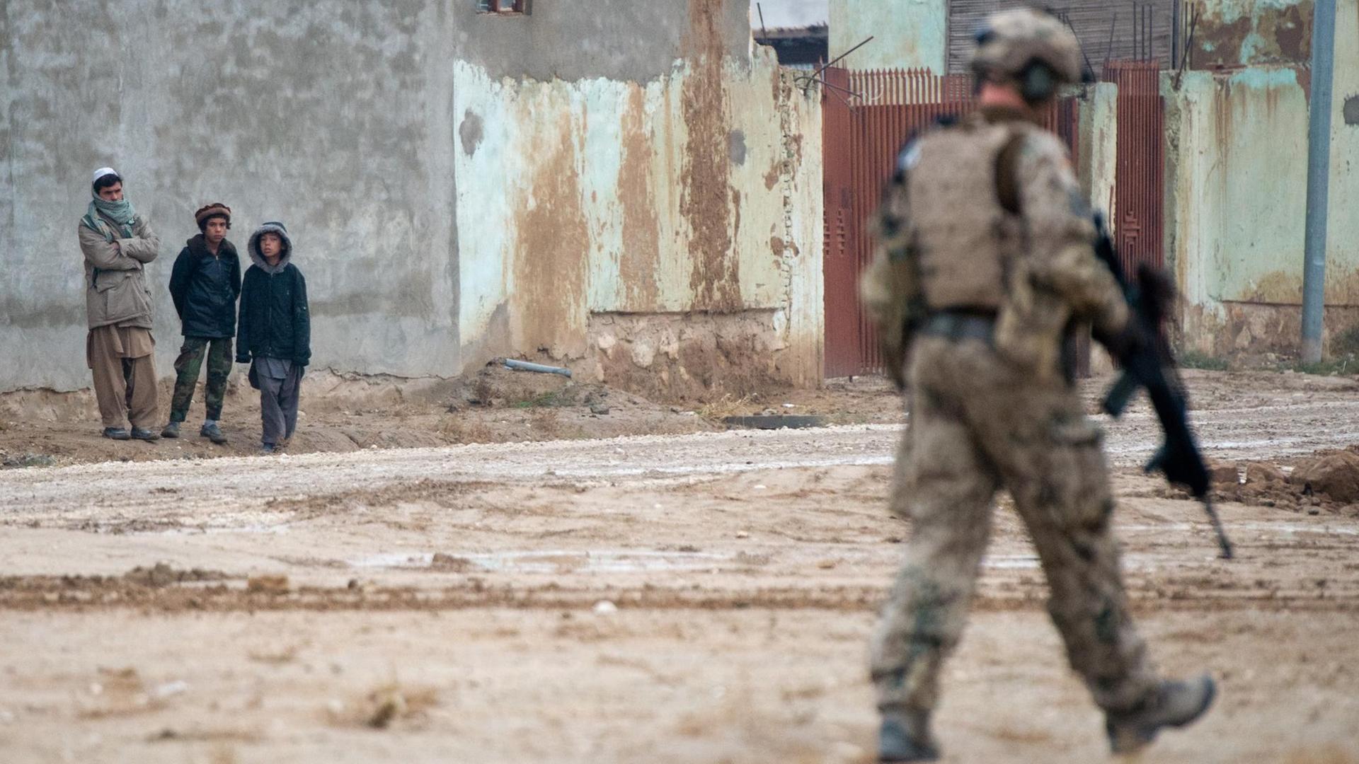 Ein Bundeswehsoldat sichert am 11.12.2013 in Masar-i-Scharif (Afghanistan) die Straße. Ein Bundeswehsoldat sichert am 11.12.2013 in Masar-i-Scharif (Afghanistan) die Straße.