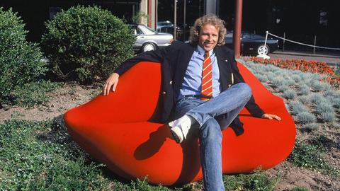 Die Schauspieler Thomas Gottschalk posiert auf einem roten Kuss-Sofa bei einem Pressetermin.